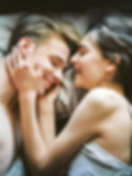 a man and woman laying in bed together snuggling