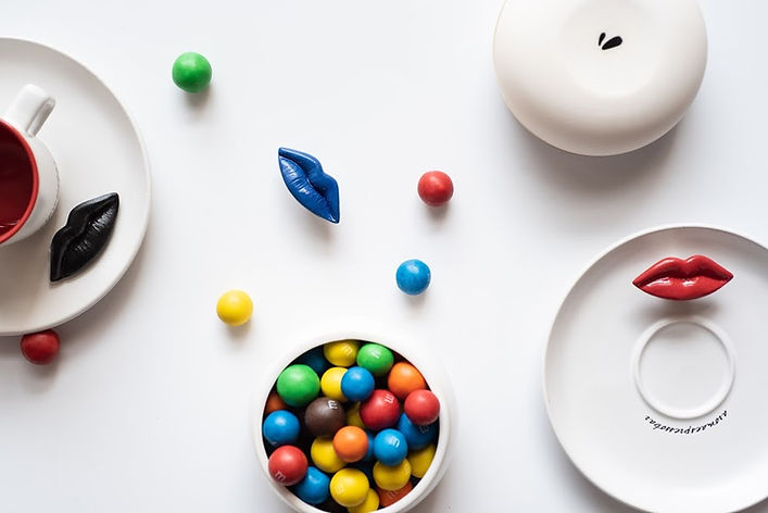 White plates with lip decorations, a red cup, and colorful candies