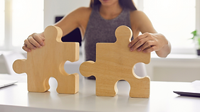 business woman fitting two large pieces of a wooden puzzle, effort to comply with the changing laws, regulations and stakeholders demands