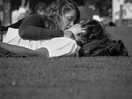 A couple kissing on the grass