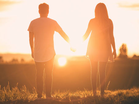 A couple holding hands at sunset