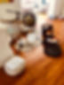 A scene of Lariss'a sound bath set up with crystal bowls, a gong, microphone stand on a beautiful hard wood floor with daylight peering in the scene.