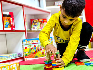 Criança brincando com blocos de montar educativos em sala de aula do colégio CEDEMI, estimulando criatividade e desenvolvimento infantil