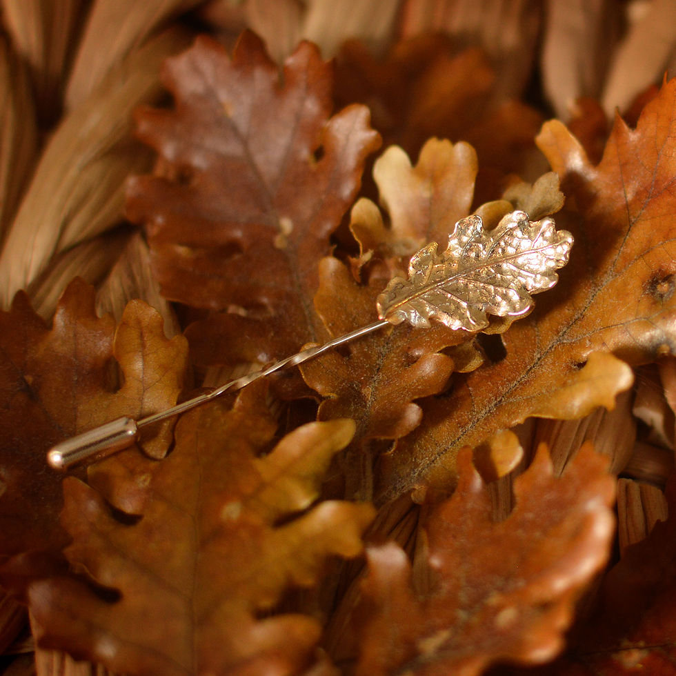 Thumbnail: Gold stick tie pin with gold oak leaf against autumn oak leaves background