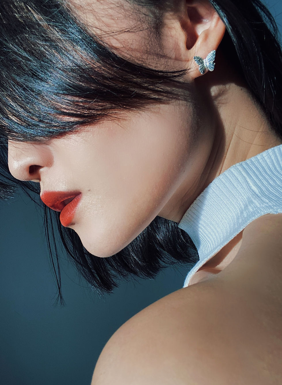 Thumbnail: Chinese woman's lower left face, eye covered by black hair, red lips, and white gold earring