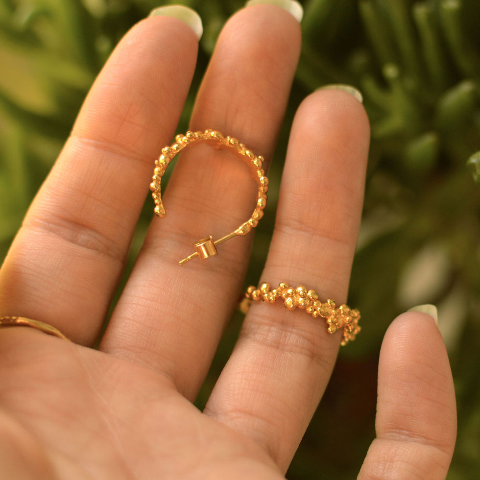 Thumbnail: Gold bubble textured hoop earrings Held in hand