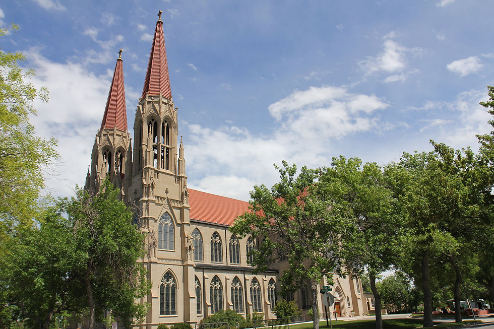 Twin spires of the Cathedral of Saint Helena rising above green trees in Helena Montana