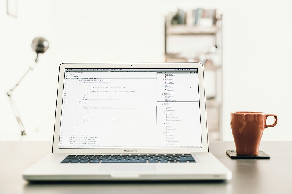 MacBook Pro beside brown mug
