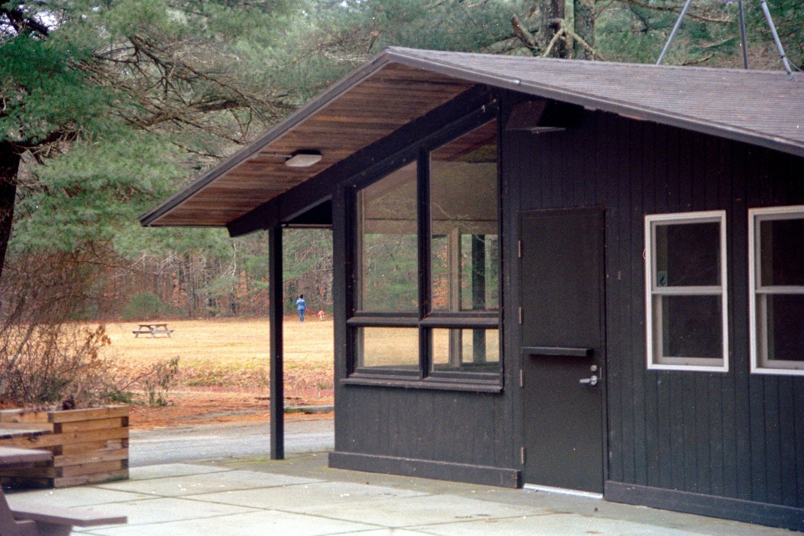a small cabin with a picnic table and benches, empty of people