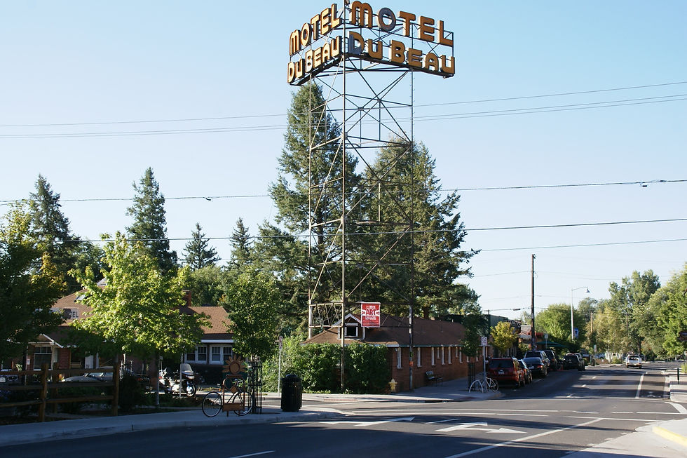 Tree lined Beaver Street on Flagstaff's Southside with a vintage motel sign overhead
