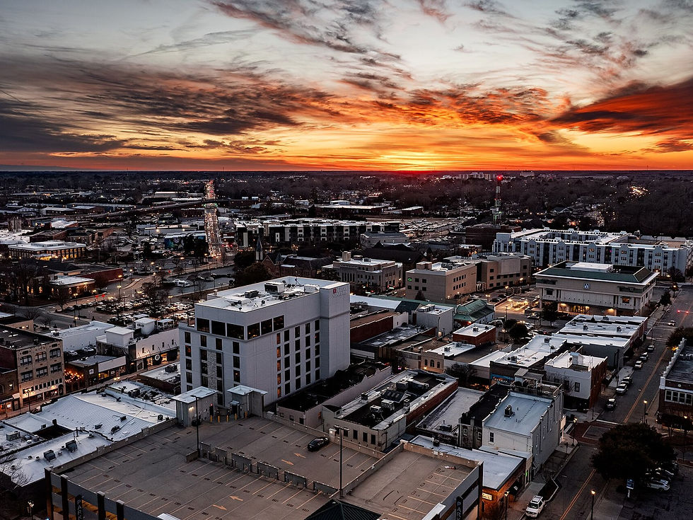 Downtown Greenville NC aerial at sunset over mid-rise hotel block — no people as subject