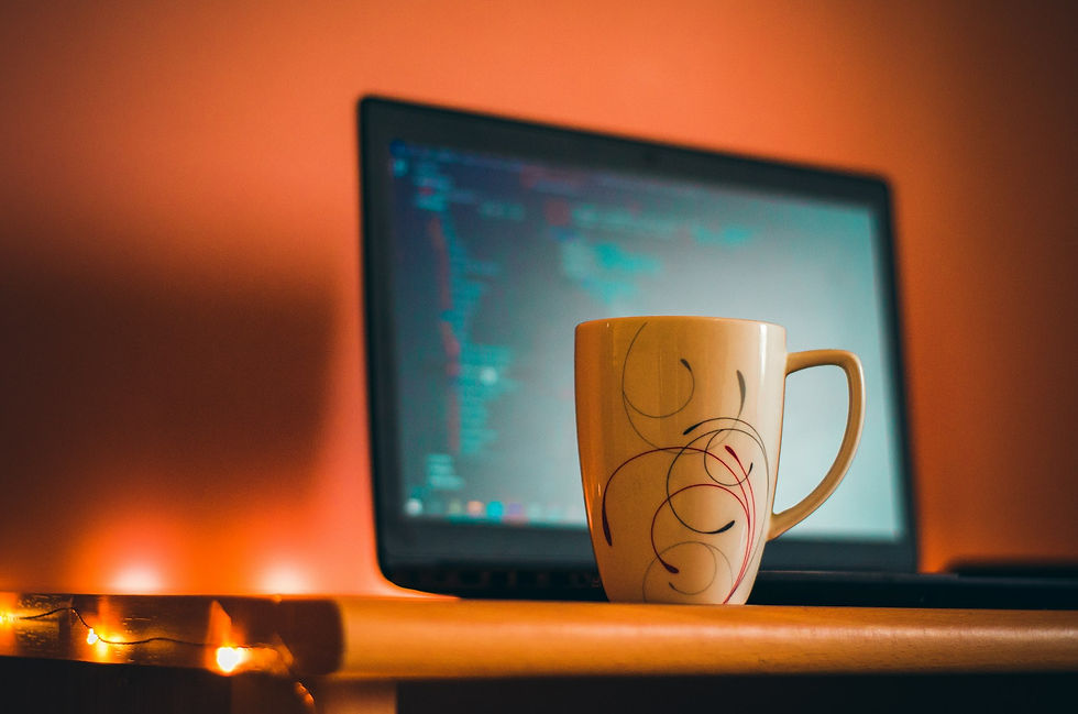 A coffee cup sitting on a desk next to a laptop