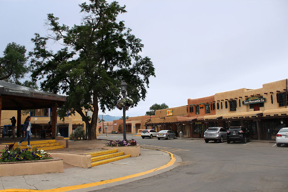 Adobe shop portals curving around the edge of the historic plaza in Taos, New Mexico