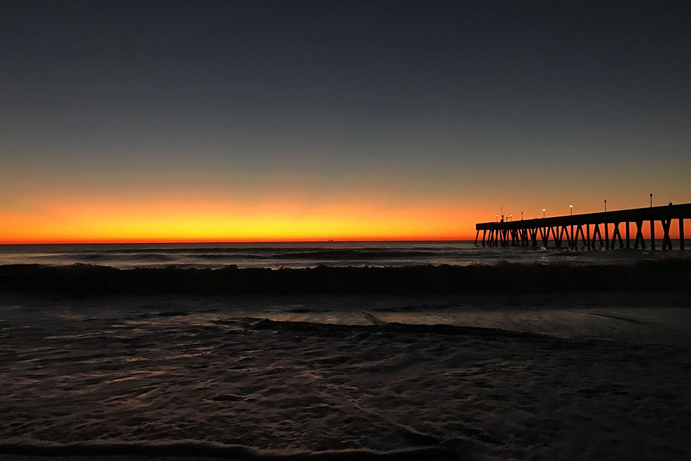 Sunrise silhouette of Johnnie Mercers Pier at Wrightsville Beach, North Carolina.