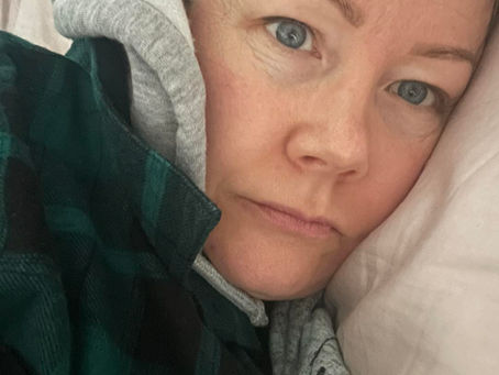 Aliesha Bannister cuddled up in bed on the active days of endometriosis.