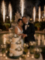 Taglio della torta durante un elegante matrimonio serale con fontane luminose, organizzato da Maison Lumière Wedding Events in una location esclusiva.