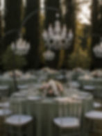 Ricevimento di matrimonio con tavoli elegantemente apparecchiati, lampadari scenografici, composizioni floreali e mise en place progettata da Maison Lumière Wedding Events.