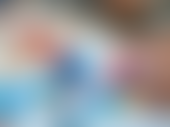 Child's hands painting with colourful melting ice blocks on paper