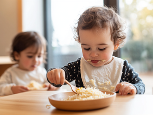 Toddler self-serving food from a bowl onto their plate at a childcare mealtime setting