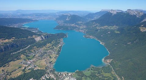 Vue aérienne du lac d’Annecy entouré des Alpes en Haute-Savoie, secteur d’intervention de Médic’Alpes.