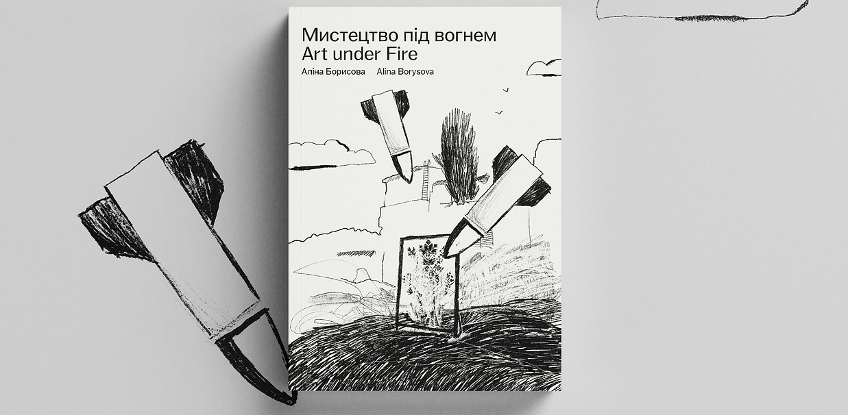 На фото мальопис "Мистецтво під вогнем", книжка з м'якою обкладинкою на сірому фоні