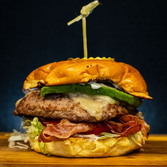 Gourmet beef burger with bacon, cheese, and jalapenos