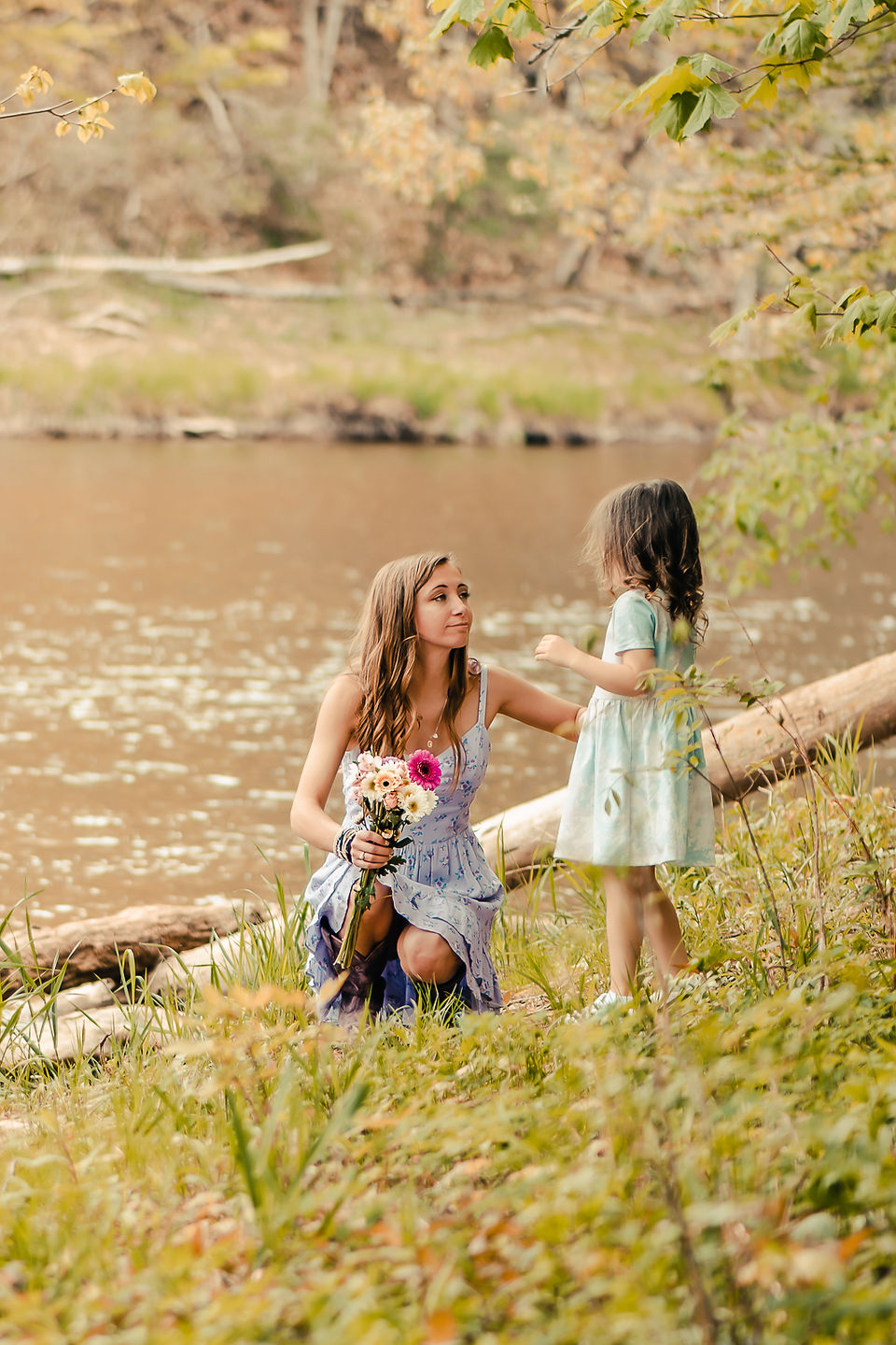 A mother talking to her daughter alongside a river