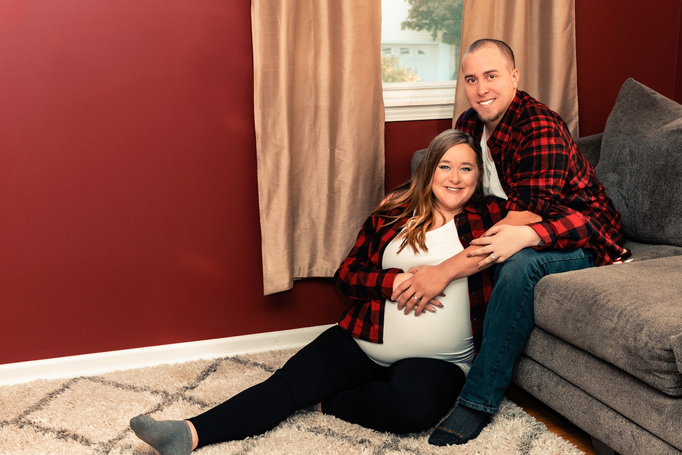 Maternity photo of a couple sitting together in their living room
