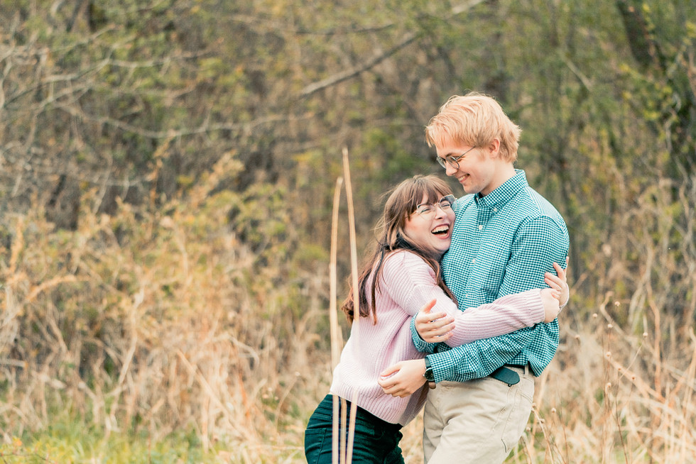 A woman hugs her fiancé as they both laugh