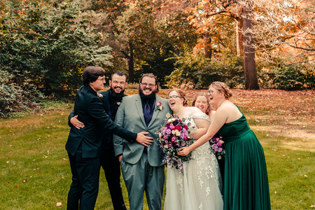Bridal party photo of a couple laughing with their bridesmaids and groomsmen