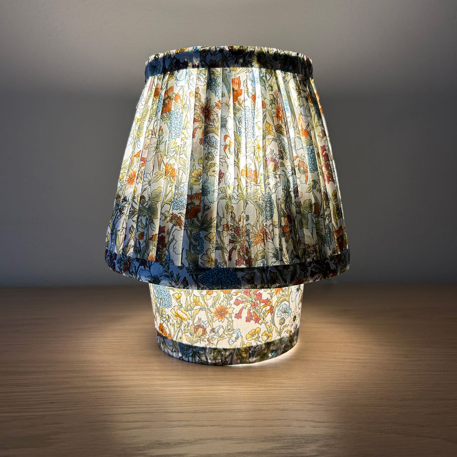Liten bordlampe med blomstret mønster og plissert skjerm