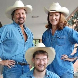 Three people wearing matching denim shirts with matching straw cowboy hats.