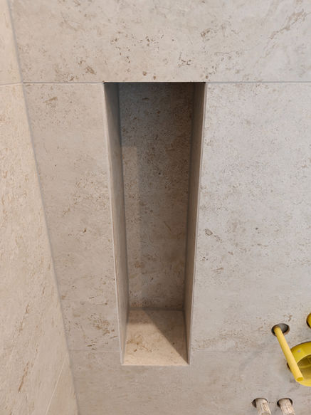 Integrierte WC-Bürstennische in der Vorwand und Fliesen im 45-Grad-Gehrungsschnitt ohne Abschlussprofile