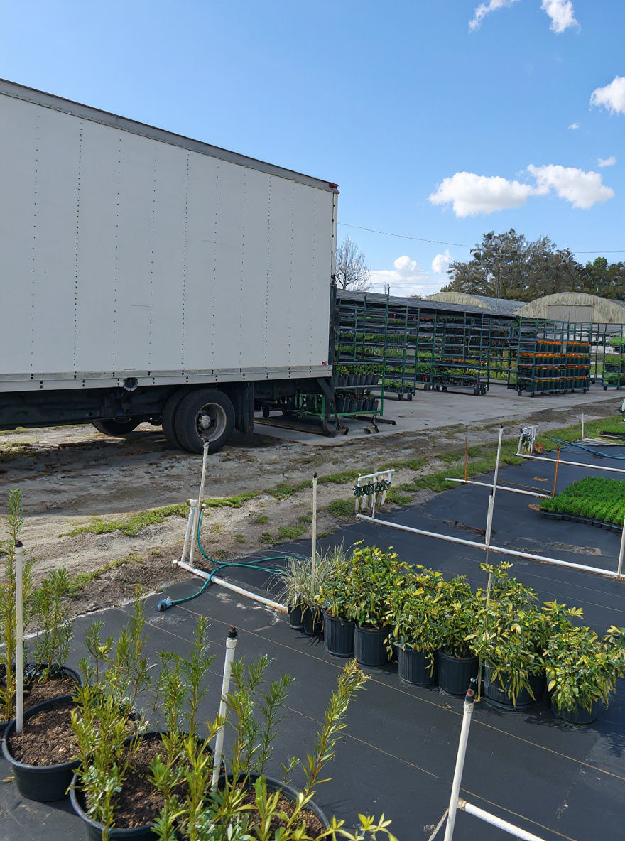 Image of a white box truck dropping green carts on the loading pad.