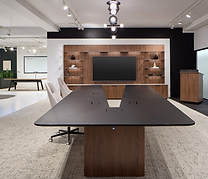 Modern office conference room with a large table, TV, and chairs.