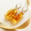Thumbnail: Light cognac rectangle shape amber earrings