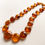 Thumbnail: Large coin shape bright cognac natural amber statement necklace