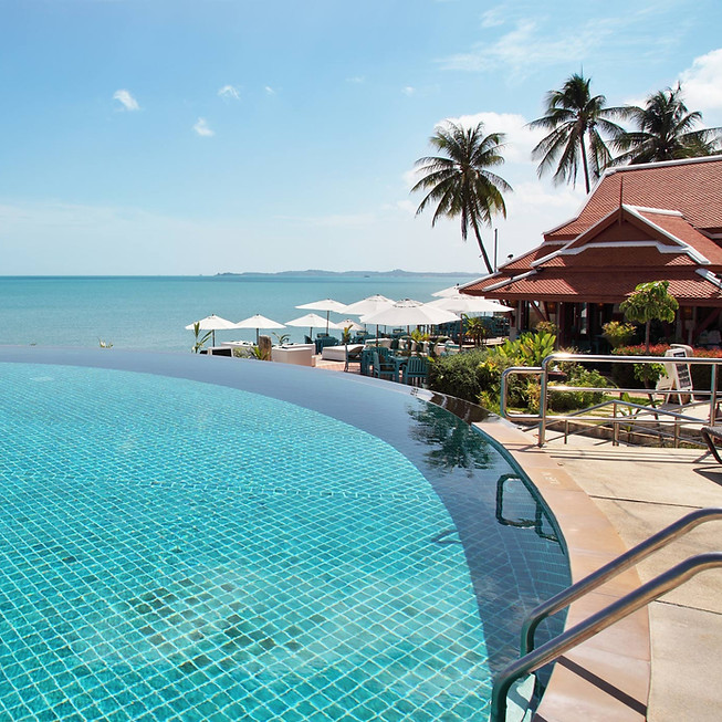 A luxury Caribbean resort with an infinity pool overlooking the blue ocean below.