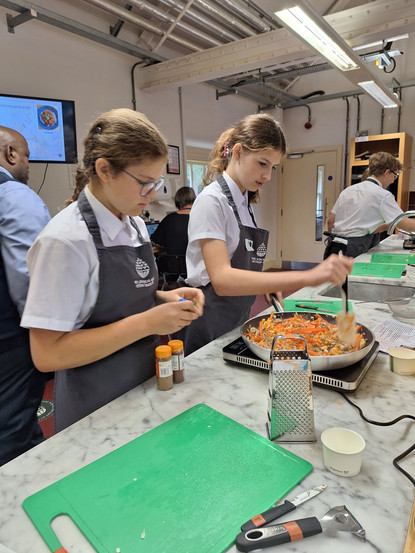 Pupils cooking food in a cookery class