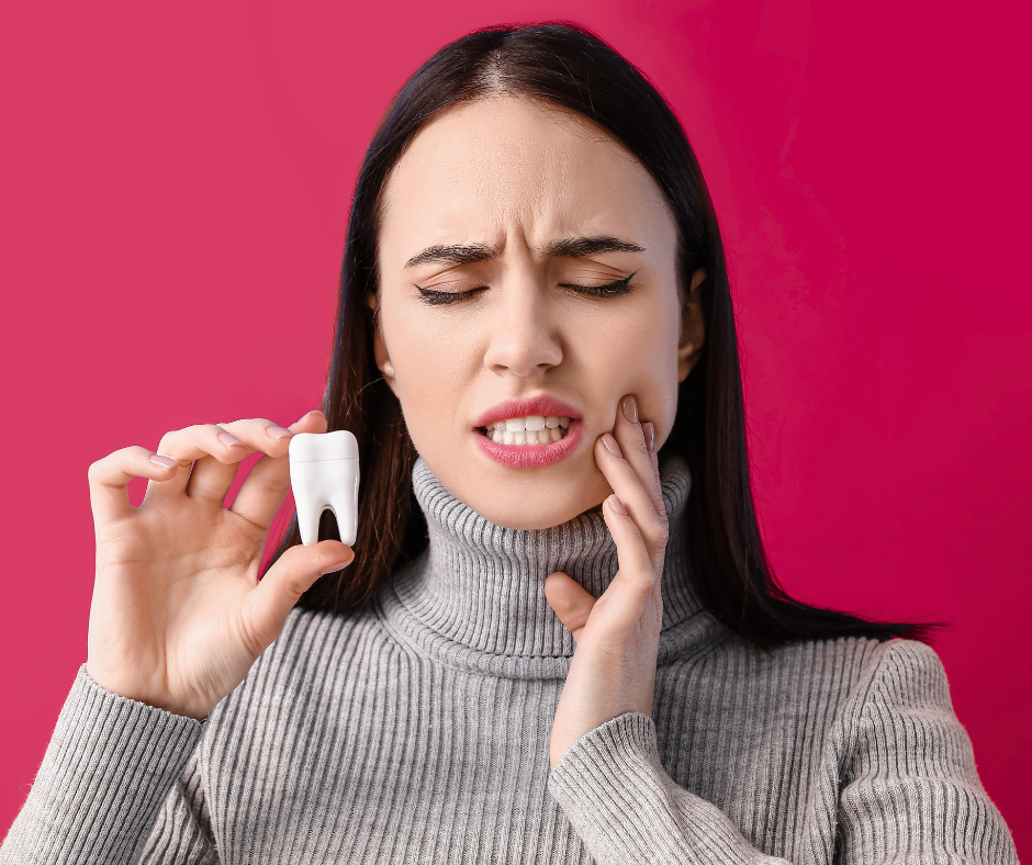 A woman holding the side of her face where her teeth are because they're in pain from sensitivity, a woman holding a model of a tooth