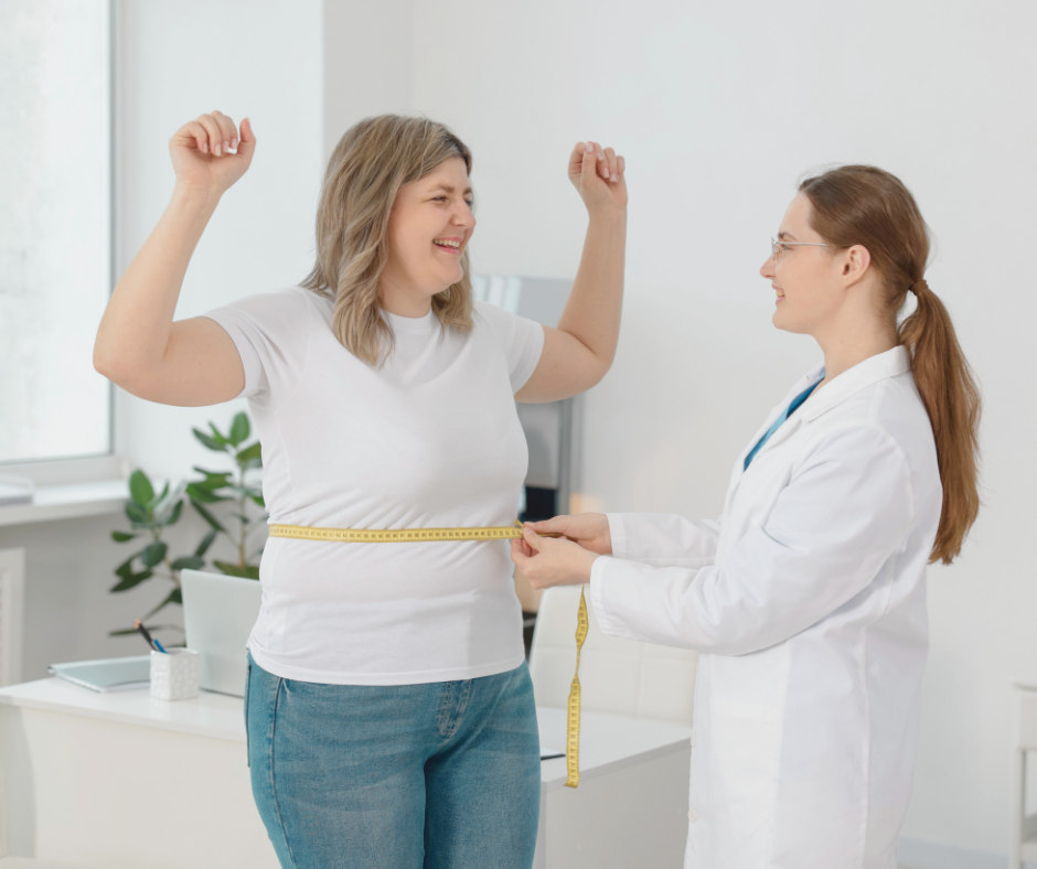 A woman smiling with her arms up, provider measuring her waist to see the progression of physician assisted weight loss