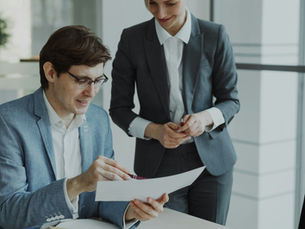 Two business colleagues reviewing financial reports together in a modern office