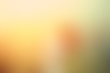 A woman basks in the sunlight, embracing its warmth and energy with open arms amidst a lush landscape.