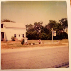 A 1980s era photograph showing Scoop Deck building with a very small empty parking area and a very quiet Eldridge Road., very different than today in season.