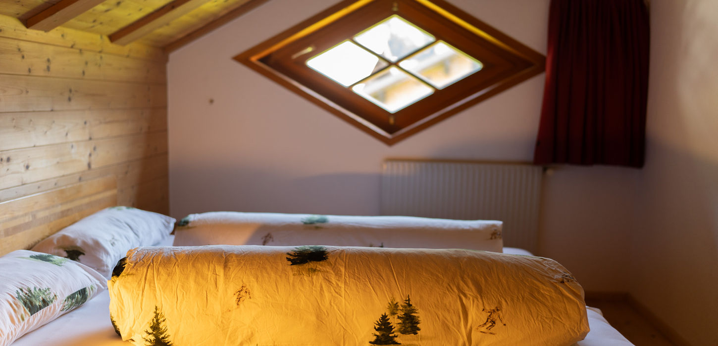 Gemütliches Schlafzimmer mit Holzverkleidung und Dachfenster