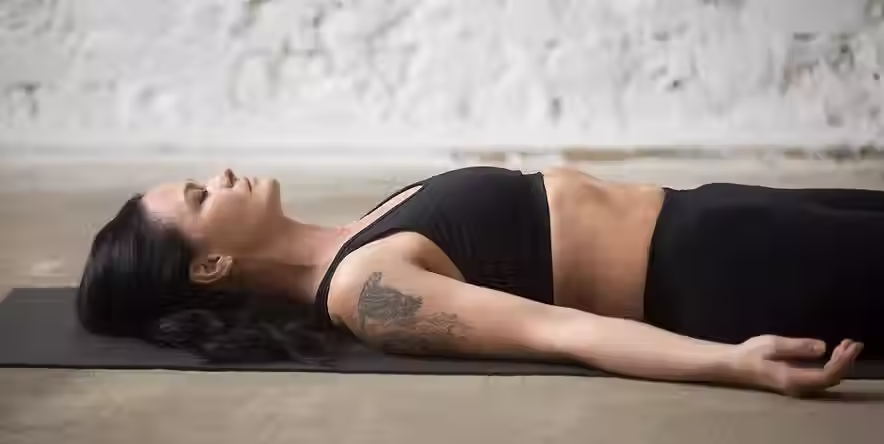 jonge-yogi-aantrekkelijke-vrouw-savasana-pose-loft-achtergrond