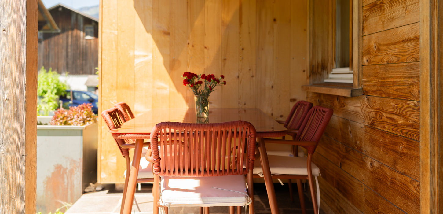 Sonniger Außenbereich mit Tisch und Stühlen