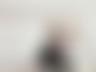 Small white dog wearing acrylic pet tag and black sweater