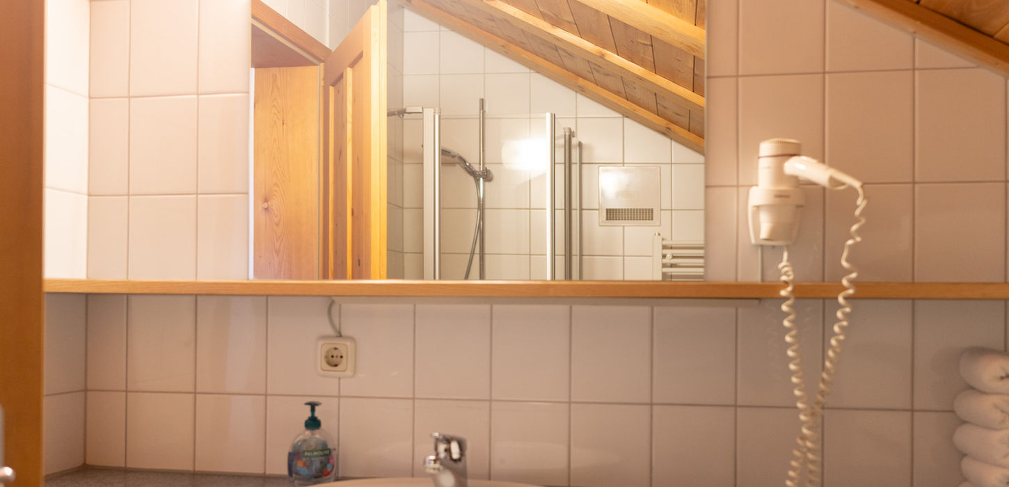 Modernes Badezimmer mit Spiegel, Waschbecken und Haartrockner