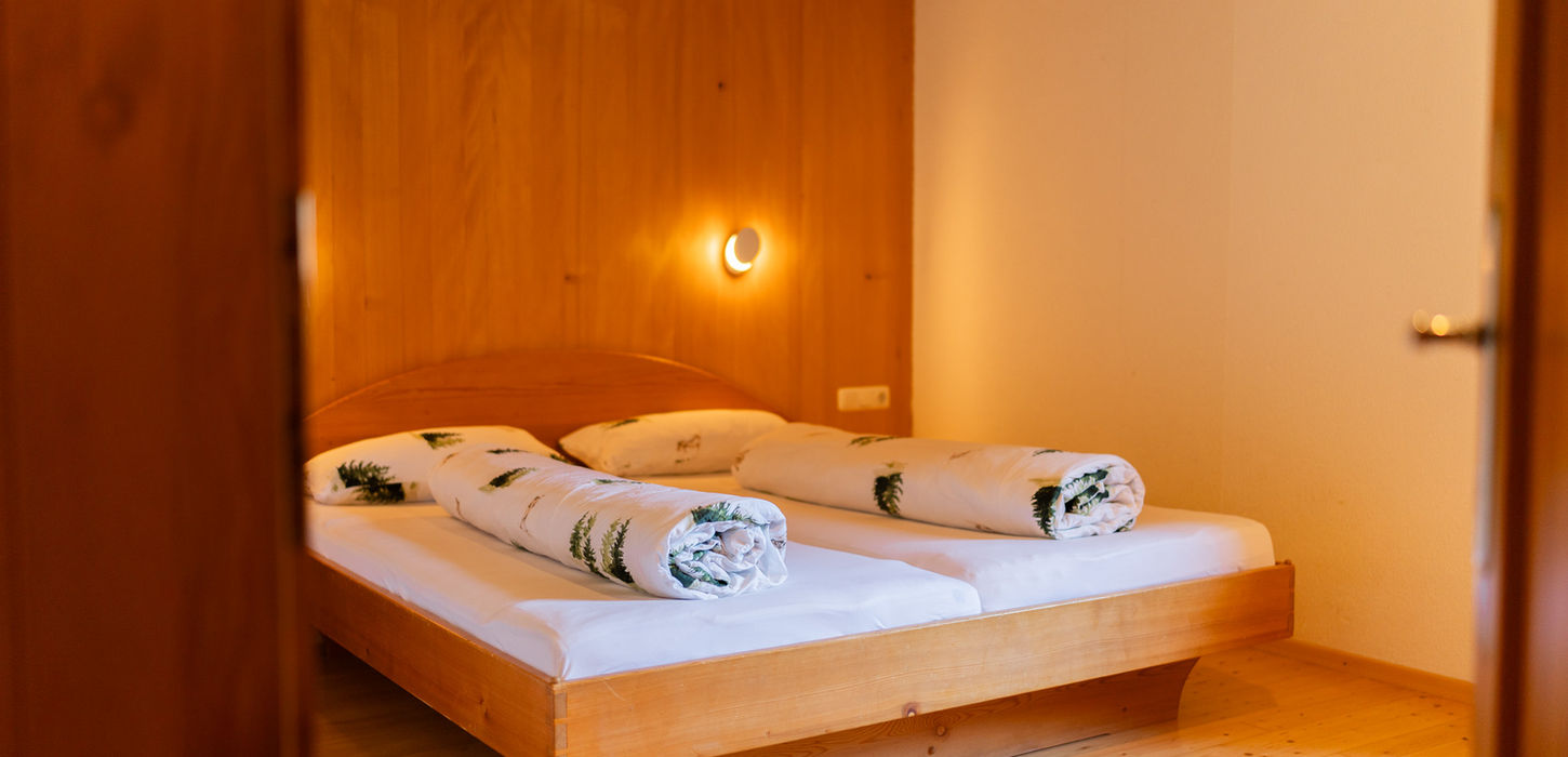 Holzbettenzimmer mit gemachten Betten